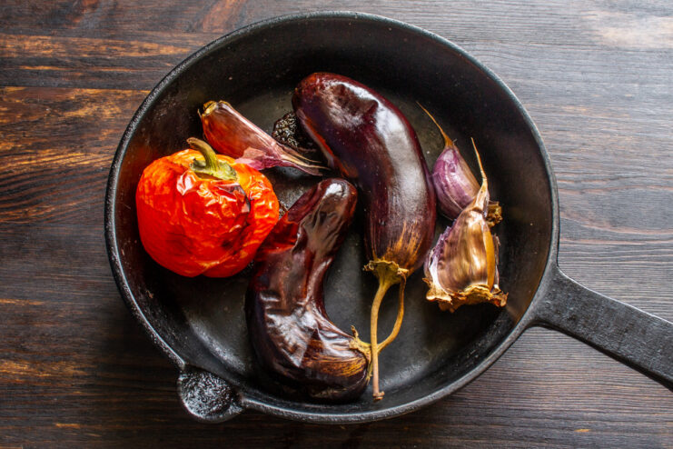 Roasting Vegetables in the Oven for the Dip Eggplant, bell pepper, and garlic on a baking sheet, ready to be placed in the oven for roasting.