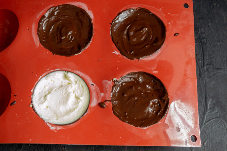 Sealing the Mascarpone Bars with a Final Chocolate Layer A final layer of melted chocolate being spread over the mascarpone filling to seal the bars.