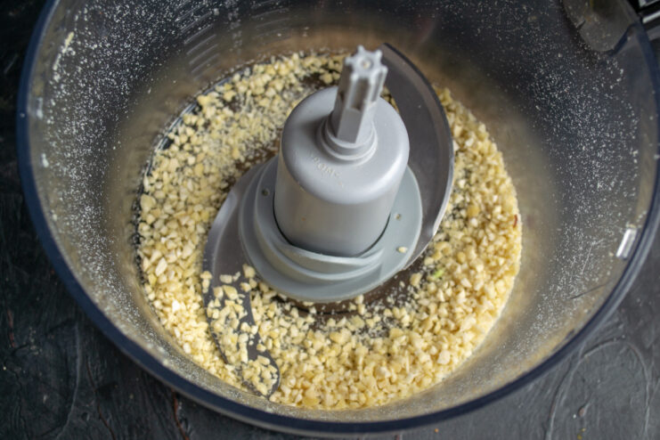 Grinding Toasted Almonds for the Mascarpone Filling Toasted almonds being chopped into fine crumbs in a food processor.