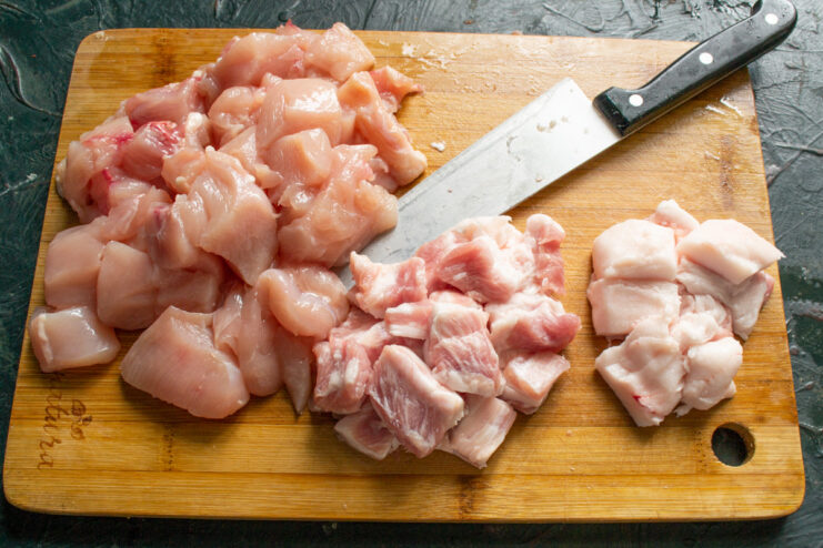 Adding Fat for Juiciness: Dicing Shpek Cured pork fatback (shpek) being cut into small cubes to add to the sausage mix.