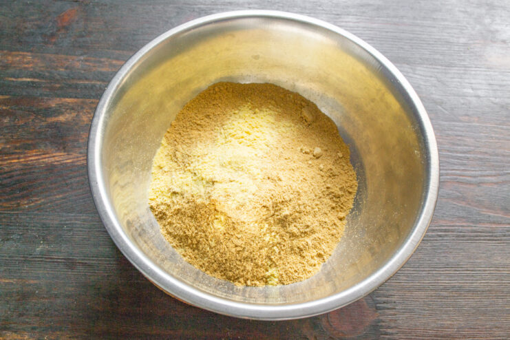 Adding Asafoetida for a Unique Flavor Twist Adding a pinch of asafoetida powder to the bowl of mustard powder.