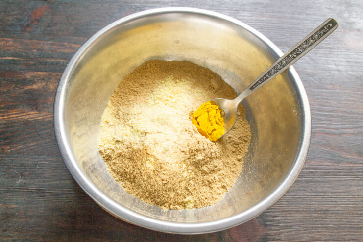 Adding Turmeric for a Vibrant Yellow Color A spoonful of bright yellow ground turmeric being added to the mustard powder.