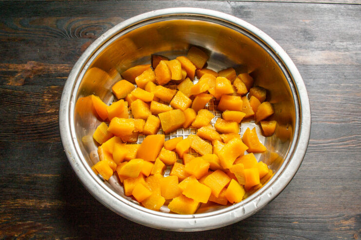 Preparing the pumpkin base for the jam Diced pumpkin cubes in a large saucepan, ready for cooking.