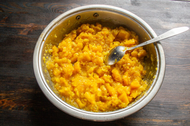 Reducing the jam to thicken it Thick pumpkin jam simmering and bubbling in a saucepan, being stirred with a spoon.