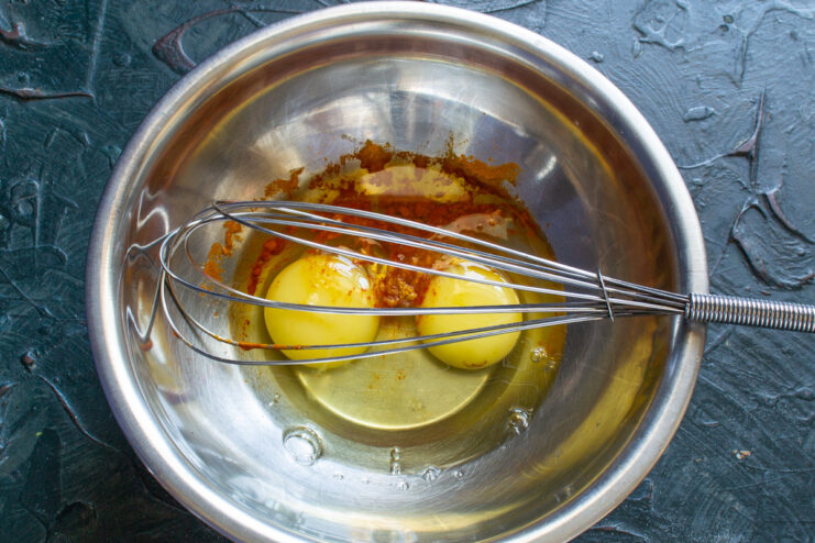 Preparing the Egg Mixture for the Frittata Two large eggs cracked into a clear glass bowl, ready for whisking.