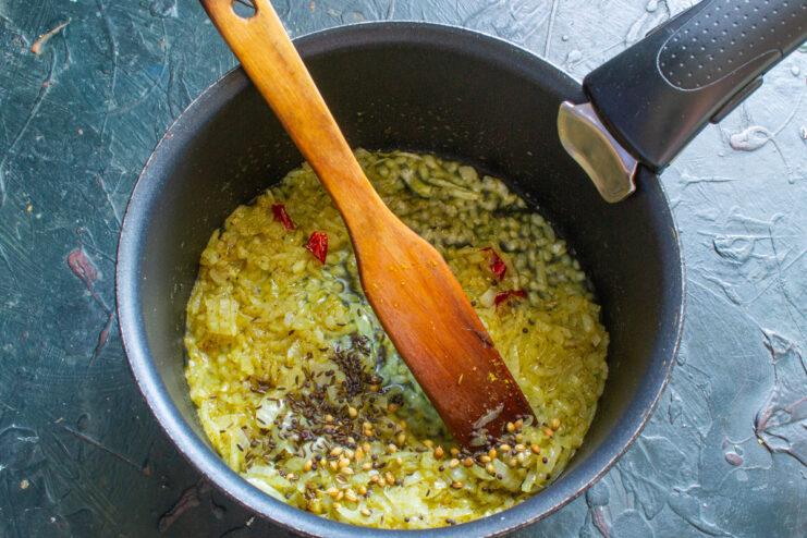 Sautéing Onions and Spices - Building the aromatic base for the sauce. Chopped onions and spices being sautéed in a pan until fragrant.