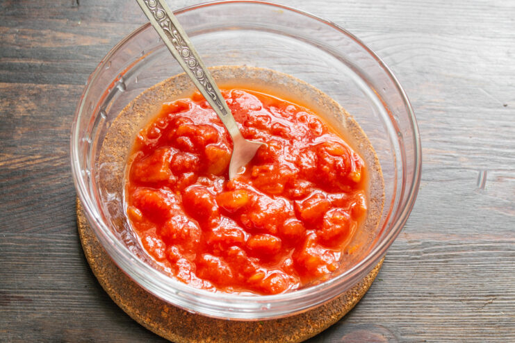 Using Canned Tomatoes for a Flavorful Year-Round Gazpacho A bowl of chopped canned tomatoes in their own juice, ready to be used for a gazpacho recipe.