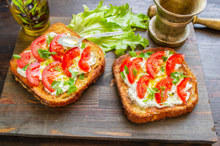 Final Seasoning: Adding Salt and Pepper to the Tomatoes Seasoning tomato-topped sandwiches with coarse sea salt and black pepper.