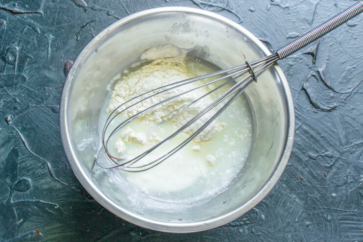 How to Make a Smooth and Creamy Sour Cream Sauce Whisking flour, water, and sour cream in a bowl to prepare a smooth sauce.