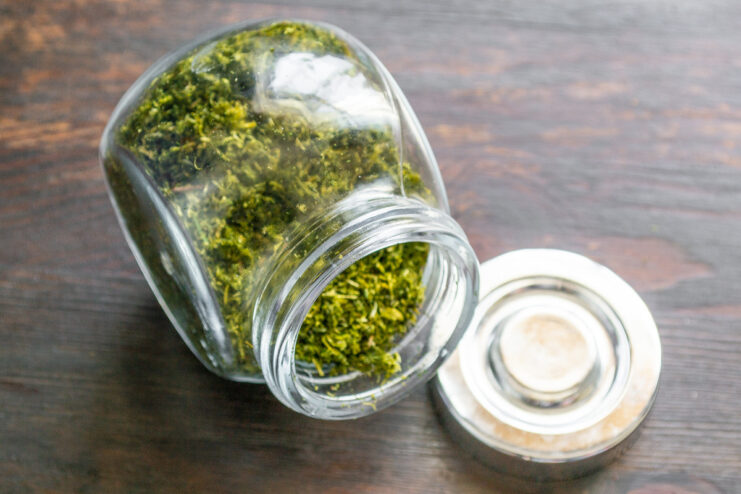 Versatile herb drying method: use it for parsley, mint, and more A glass jar filled with homemade dried dill powder, ready for storage.