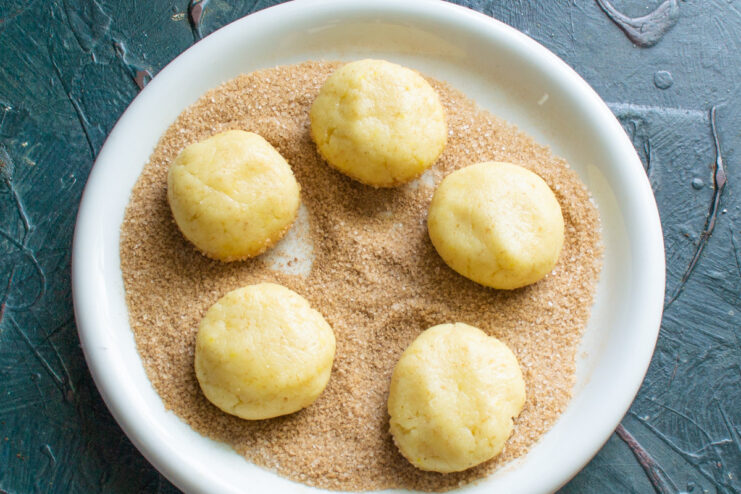 Portioning the cookie dough for even baking The cookie dough divided into small, equal-sized balls on a work surface.