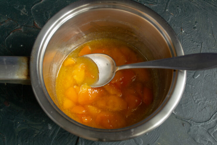 Simmering the fruit sauce until the fruit is soft Fruit sauce simmering in a saucepan on the stove.