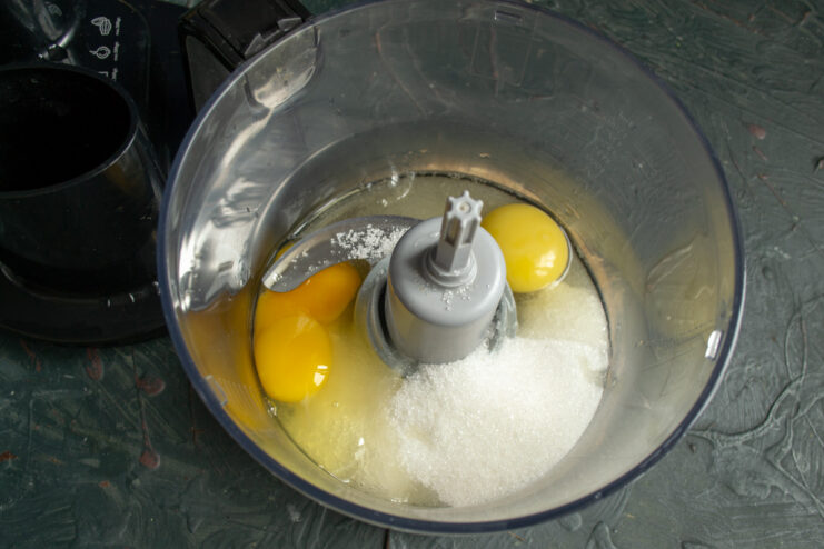 Step 1: Whisking eggs with sugar and salt for the cupcake batter A glass bowl with eggs, sugar, and salt being whisked together.