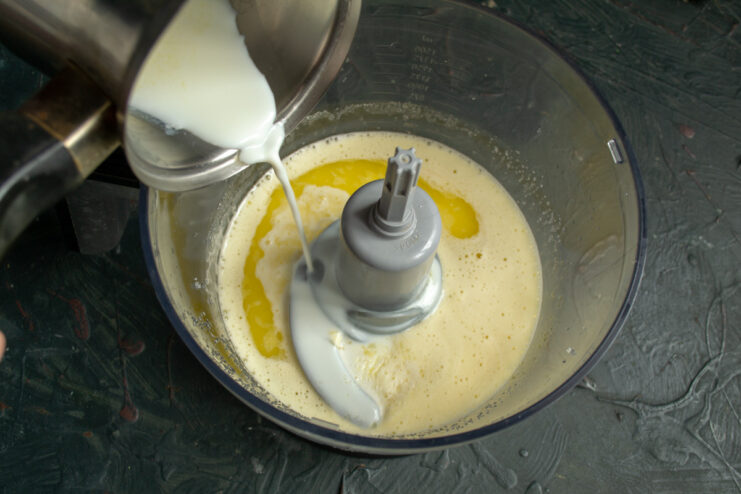 Step 3: Adding milk to the egg and sugar mixture Pouring milk into the bowl with the egg and sugar mixture.