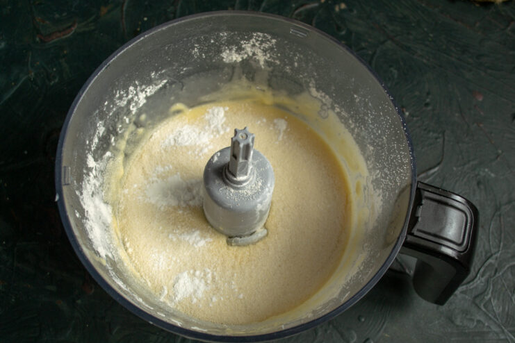 Step 5: Adding semolina and baking powder to the batter Semolina and baking powder being added to the flour in the bowl.