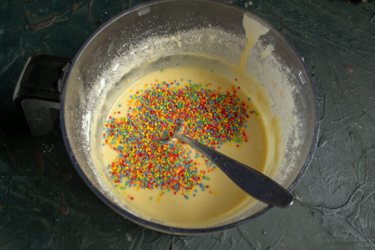 Step 6: Folding in the colorful sprinkles Adding colorful sugar confetti sprinkles into the cupcake batter.