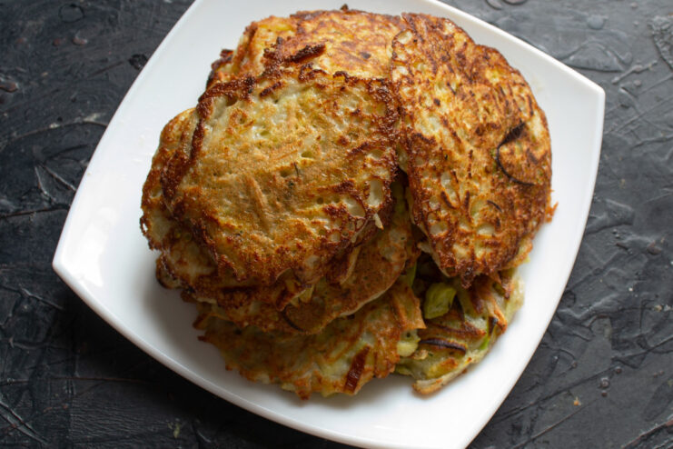 Serving Hot and Crispy Draniki A stack of freshly fried potato and Jerusalem artichoke draniki on a plate.