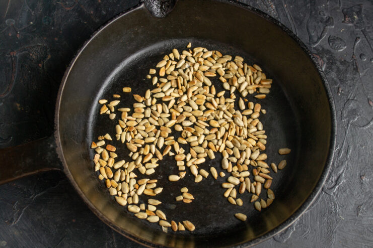 Toasting sunflower seeds in a dry frying pan until golden.