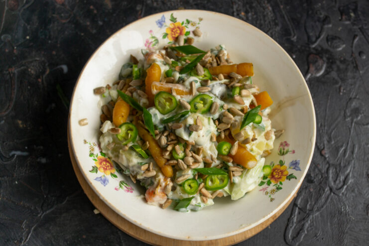 The finished 15-minute potato salad in a bowl, garnished with toasted sunflower seeds and chili.