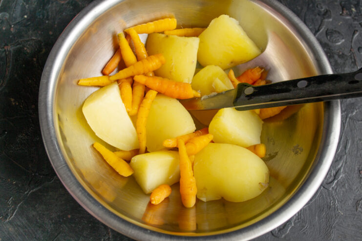 Diced new potatoes and carrots in a saucepan, ready to be boiled.