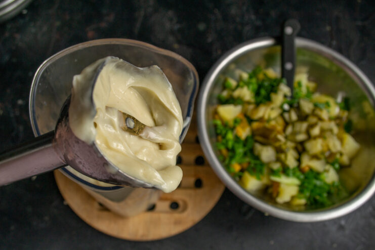 Ingredients for homemade mayonnaise in a bowl: egg yolk, mustard, and vinegar.