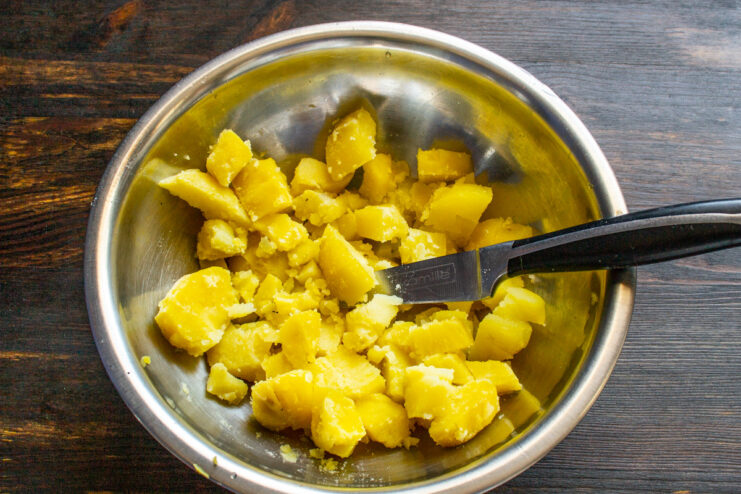 Step 1: Preparing the potatoes for the salad Diced potatoes, boiled in their skins, in a bowl.