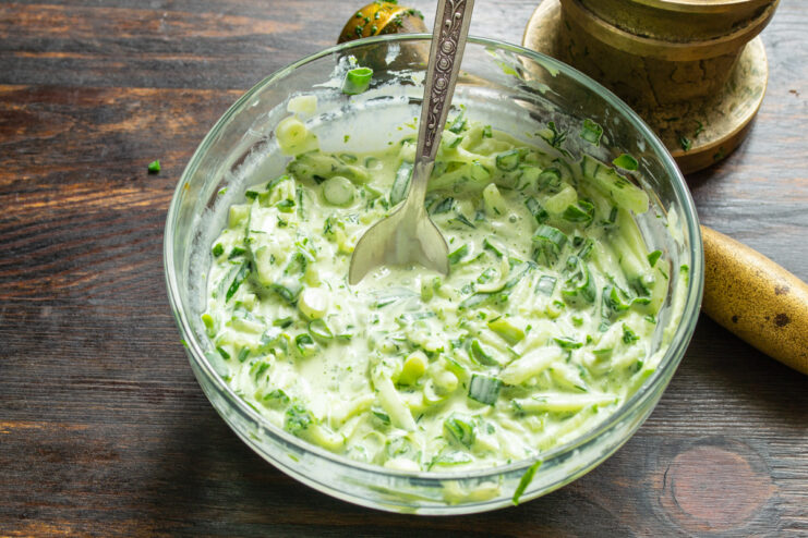 Seasoning the salad dressing Sprinkling salt into the bowl with the creamy salad dressing.