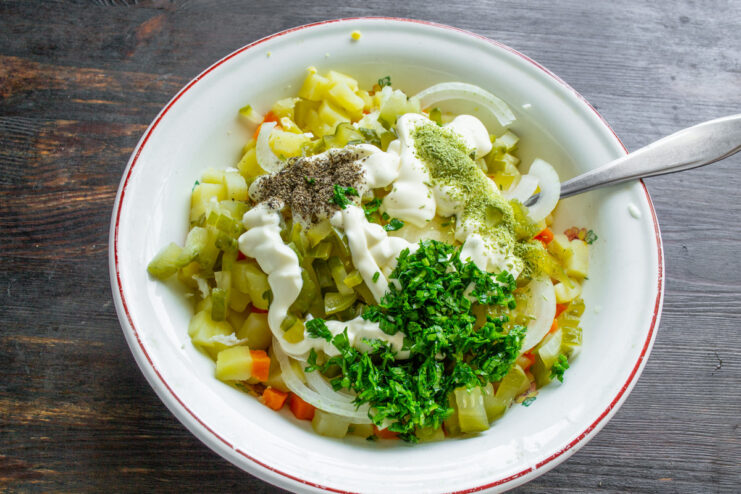 Adding finely chopped parsley to the salad bowl with other ingredients.