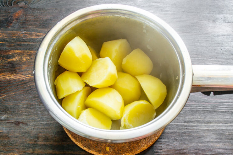 Boiling Chopped Potatoes Until Tender Chopped potatoes boiling in a pot of water on the stove.