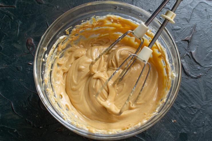 The final creamy and smooth caramel base for the muffins. A close-up of the smooth, fluffy caramel cream being mixed in a bowl.