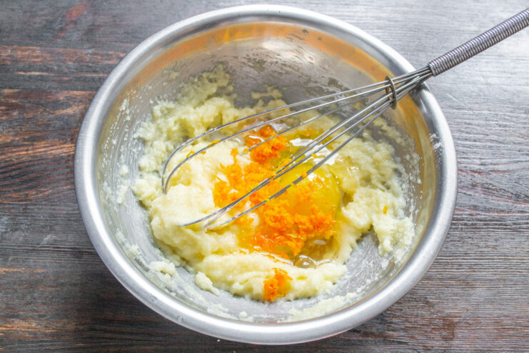 Incorporating Egg and Vanilla for a Rich Cupcake Batter An egg and vanilla extract being added to the creamed butter and sugar mixture.
