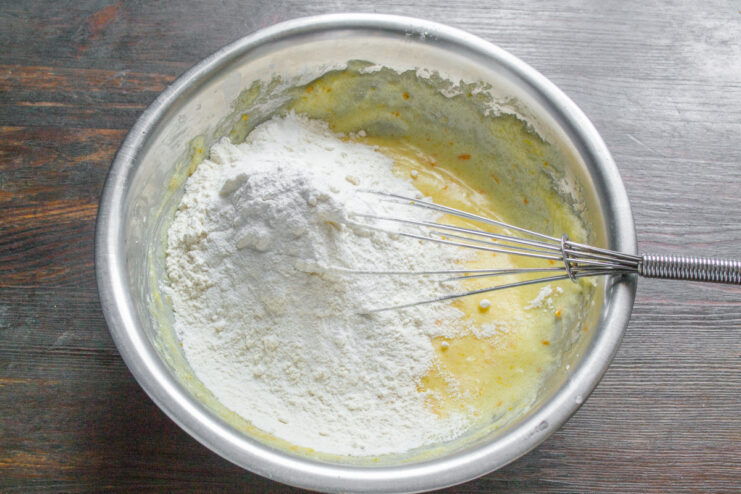 Combining Dry Ingredients: Flour and Baking Powder A bowl containing a mix of all-purpose flour and baking powder.