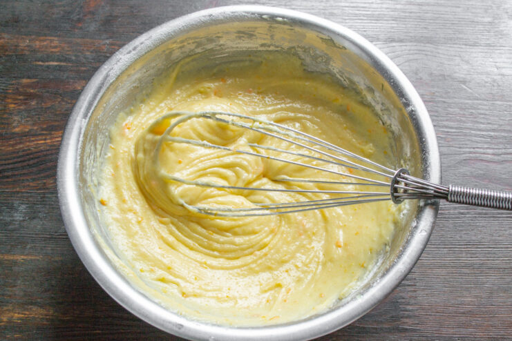 Mixing the Cupcake Batter Until Smooth and Homogeneous A whisk mixing the cupcake batter in a bowl until it's smooth.