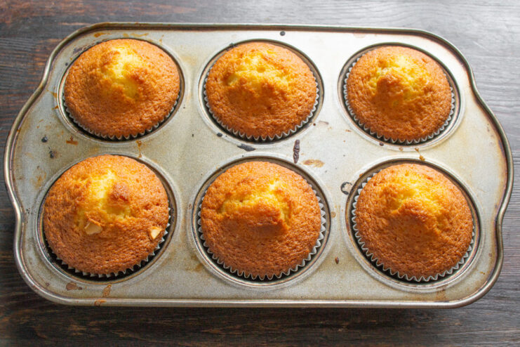 Baking the Cupcakes to Golden Perfection A muffin tin filled with cupcake batter being placed into a hot oven.