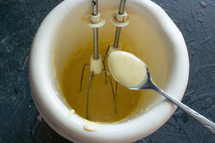 How to Emulsify Mayonnaise with an Immersion Blender An immersion blender mixing egg yolk and mustard while olive oil is being poured in.