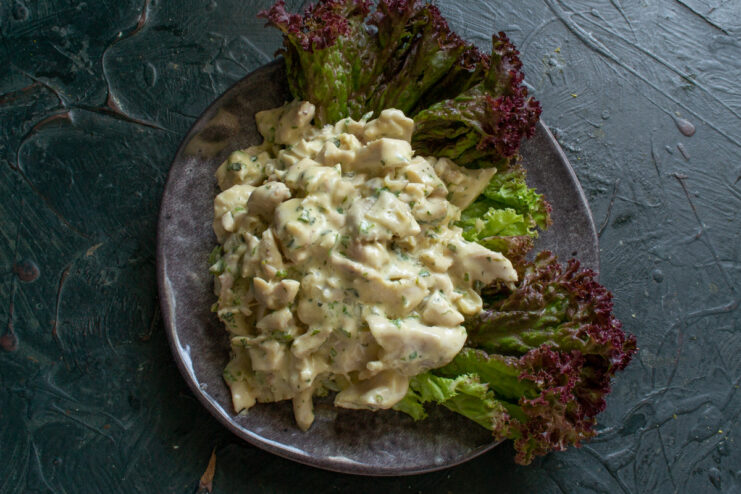 Creating a Fresh Lettuce Bed for the Chicken Salad Fresh green lettuce leaves arranged on a white plate to serve as a base for the salad.