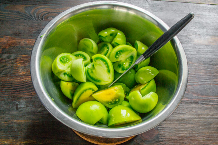 Preparing Green Tomatoes for Kimchi Chopped green tomatoes in a large glass bowl, ready for making kimchi.