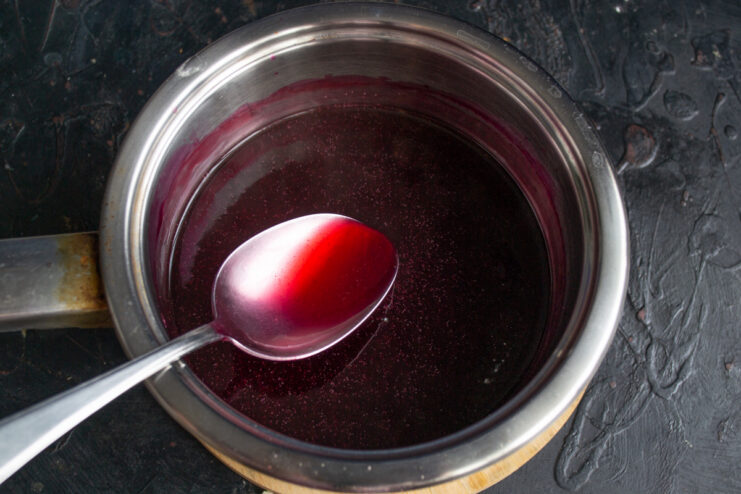 How to add starch slurry to the kisel to achieve a smooth consistency Pouring the starch slurry into the boiling blackcurrant liquid in a saucepan.