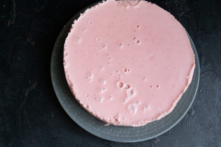 Step 12: Removing the springform ring from the set cake. Carefully removing the ring of the springform pan from the chilled strawberry cake.