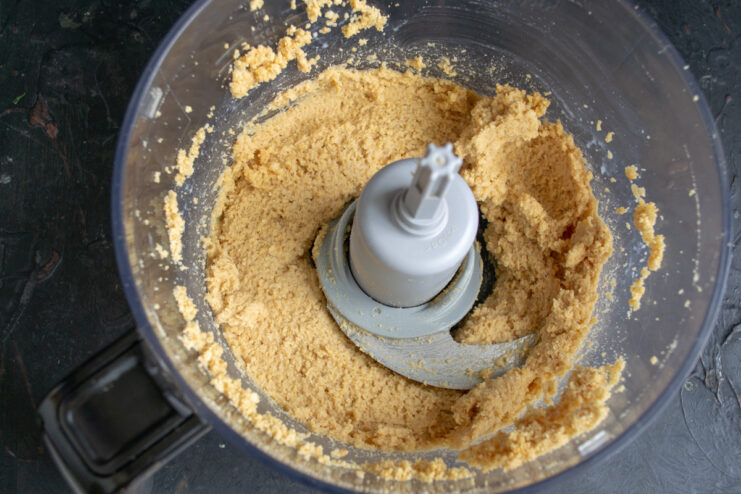Step 3: Creating a thick, sticky dough for the no-bake crust. The finished cookie and butter mixture forming a dough in the blender.