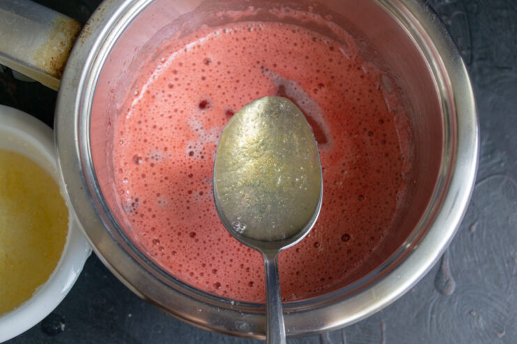 Step 8: Adding bloomed gelatin to the warm strawberry puree. Pouring the dissolved gelatin mixture into the saucepan with strawberry puree.