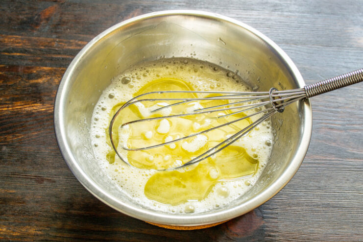 Whisking eggs and sugar until light and fluffy is key for tender muffins Close-up of eggs and sugar being whisked together in a glass bowl.