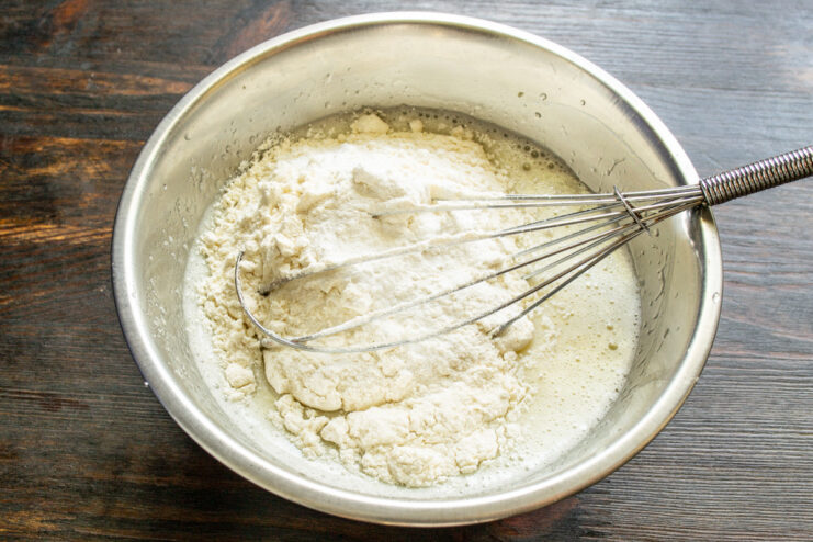 Combining dry ingredients like flour and baking powder before adding to wet ingredients Sifting flour and other dry ingredients into a bowl with the wet mixture.