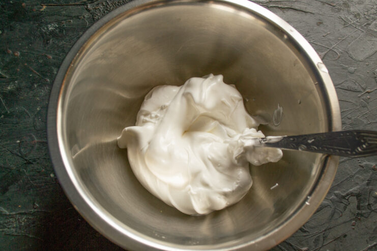 Whipping Chilled Egg Whites with an Electric Mixer for Meringue A bowl of chilled egg whites being whipped with an electric mixer.