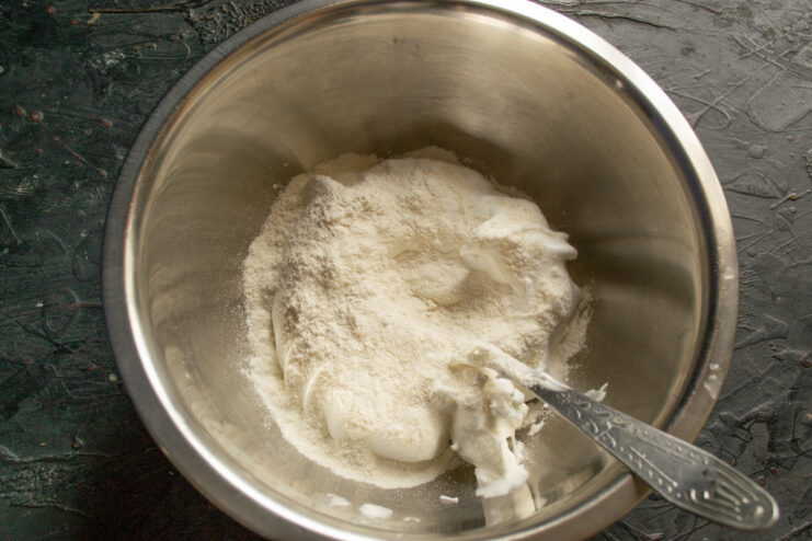 Adding Rice Flour to the Whipped Egg Whites Adding one tablespoon of rice flour to the whipped egg white mixture in a bowl.