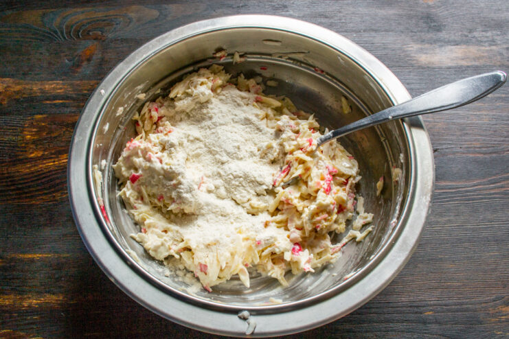 Seasoning and Thickening the Cutlet Mixture - Adding flour and salt for flavor and consistency. Sprinkling all-purpose flour and salt into the bowl with the crab stick mixture.