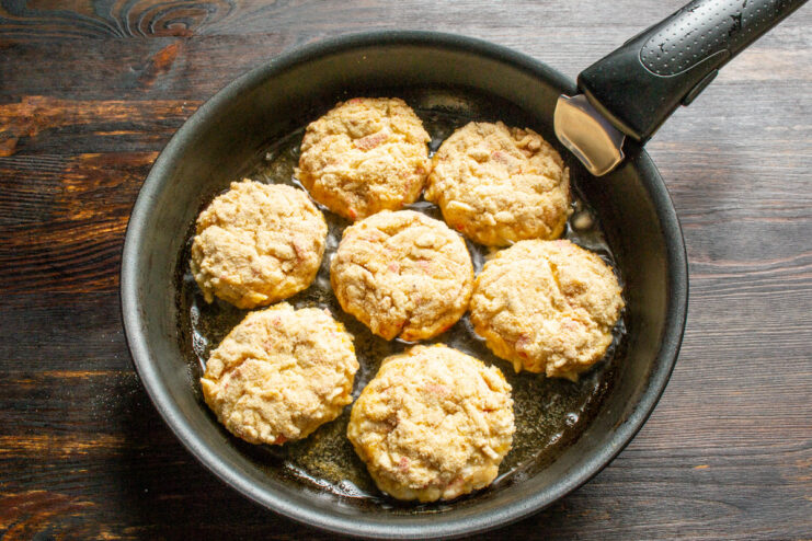 Getting a Perfect Golden Crust: Coating Cutlets Evenly - Ensure every side is covered in breadcrumbs. A hand coating a crab stick cutlet thoroughly in breadcrumbs.