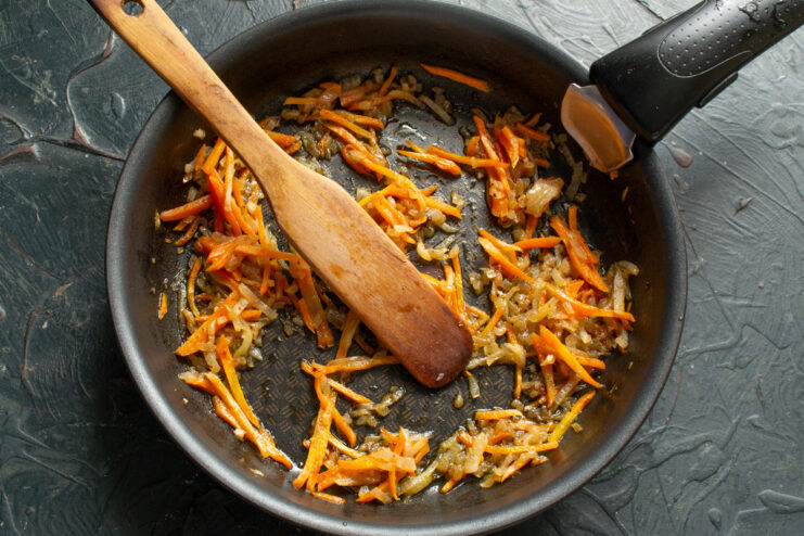 Sautéing Onions and Carrots to Build Flavor for the Salad Chopped onions and carrots being sautéed in a frying pan.