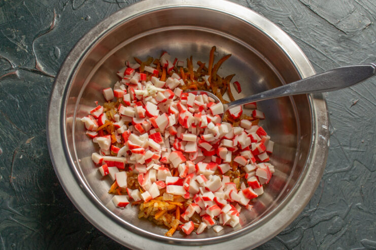 Preparing the Crab Sticks for the Imitation Crab Salad A pile of diced crab sticks on a cutting board.
