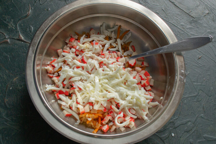 Adding Grated Egg Whites for Texture and Protein Adding grated hard-boiled egg whites to the salad bowl with other ingredients.